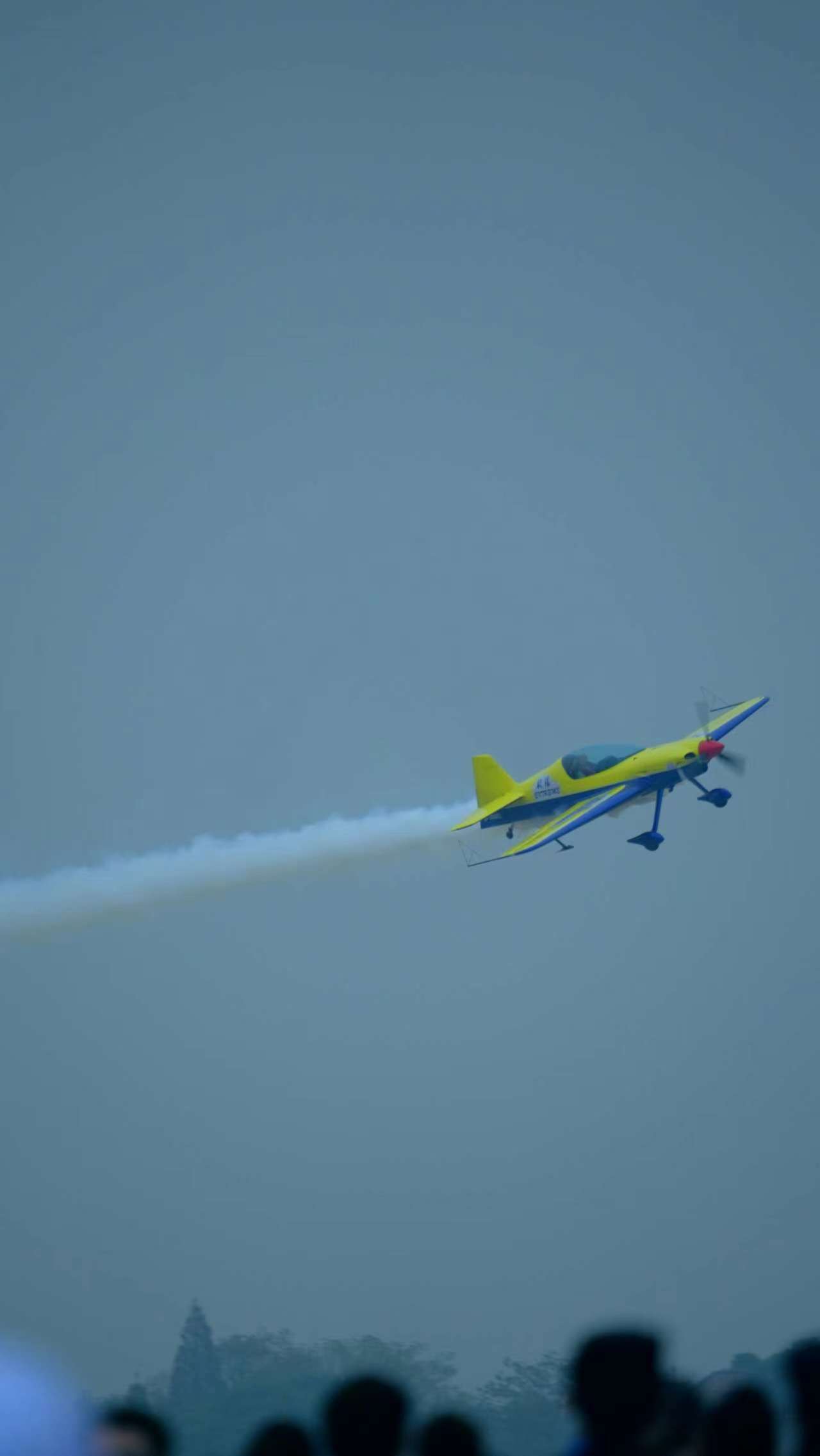 黄色特技飞机空中飞行表演人心