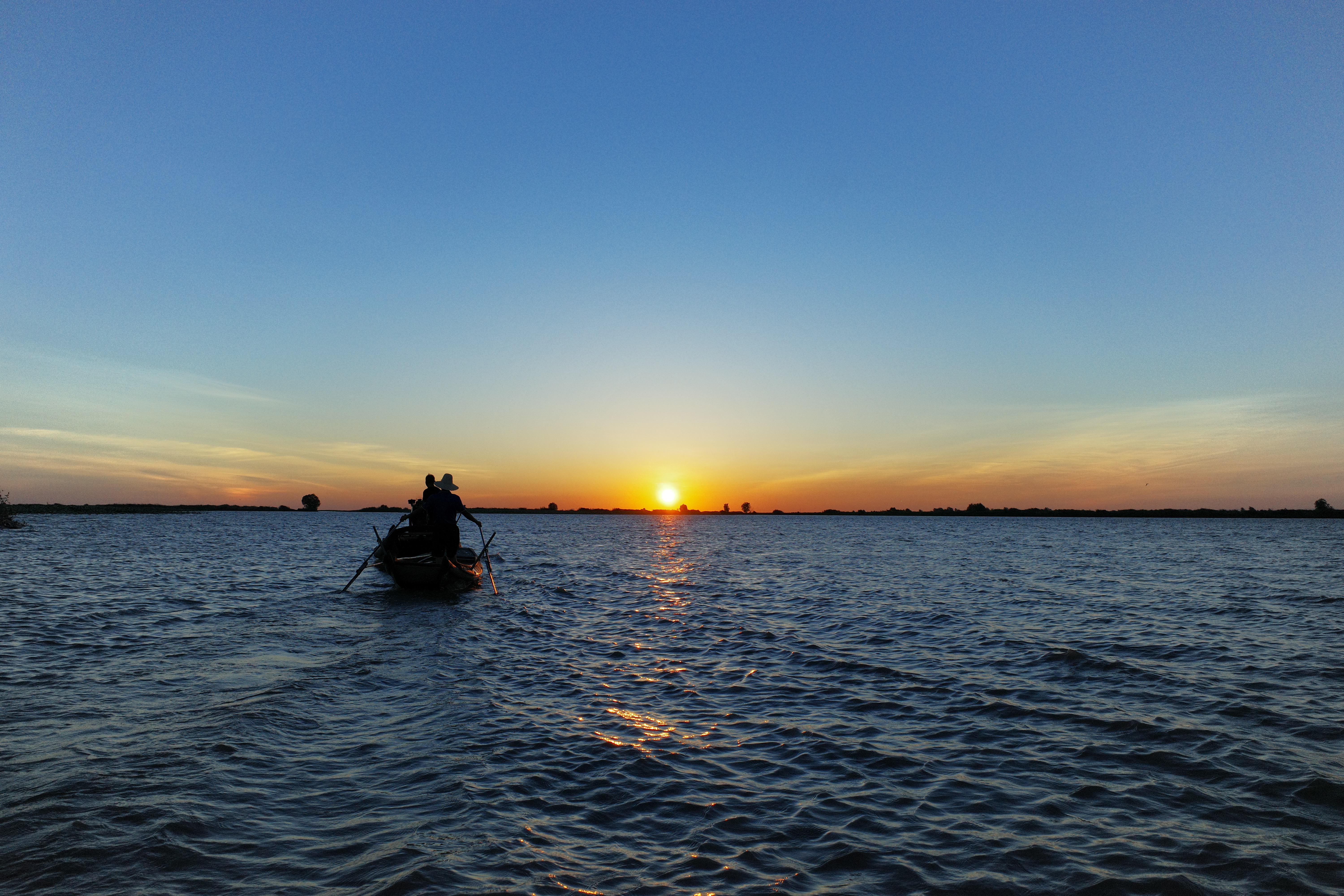 夕阳下的湖面小船，尽显悠然惬意之景