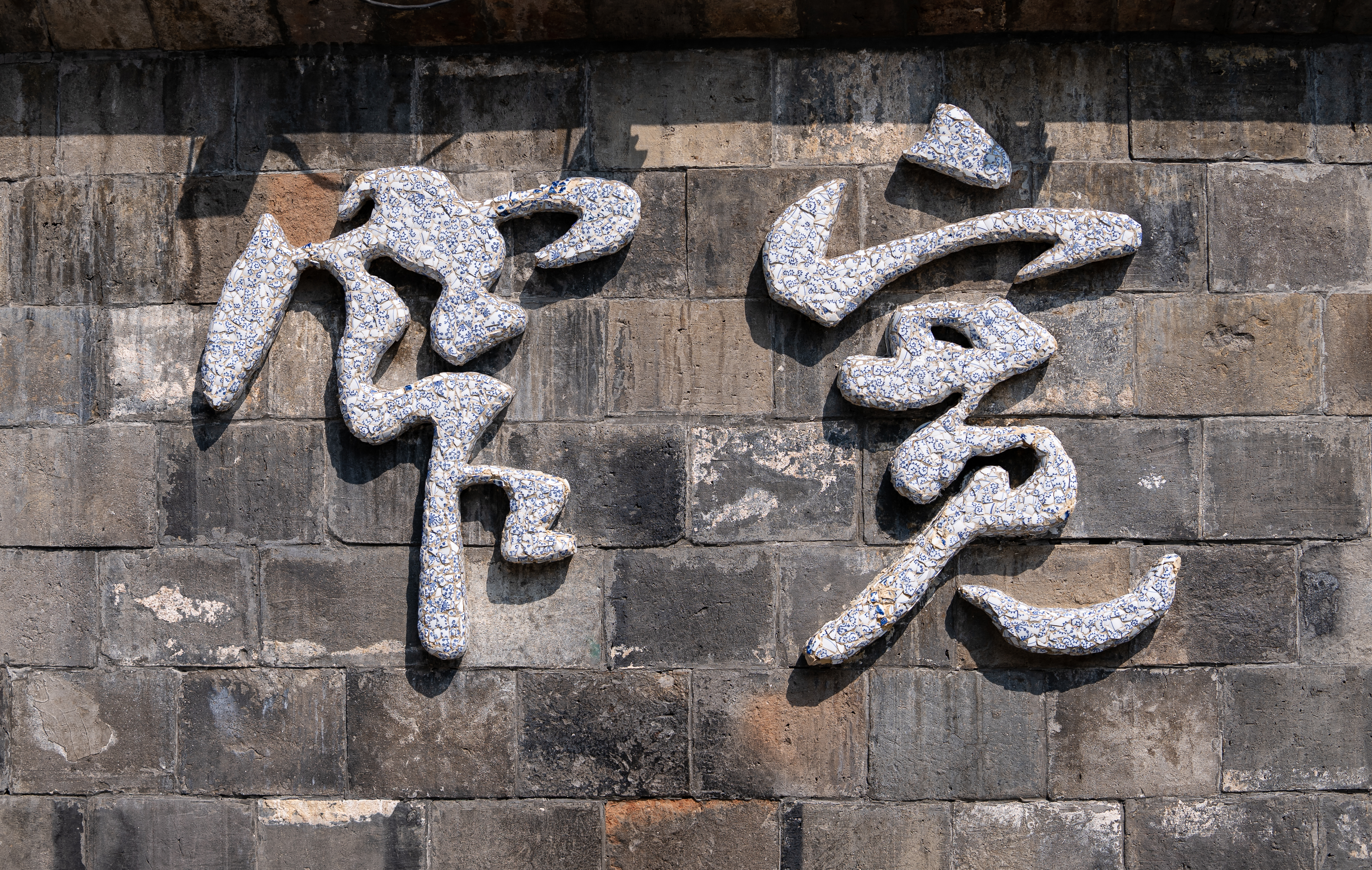 古朴砖石墙上的宽容”二字尽显中国风