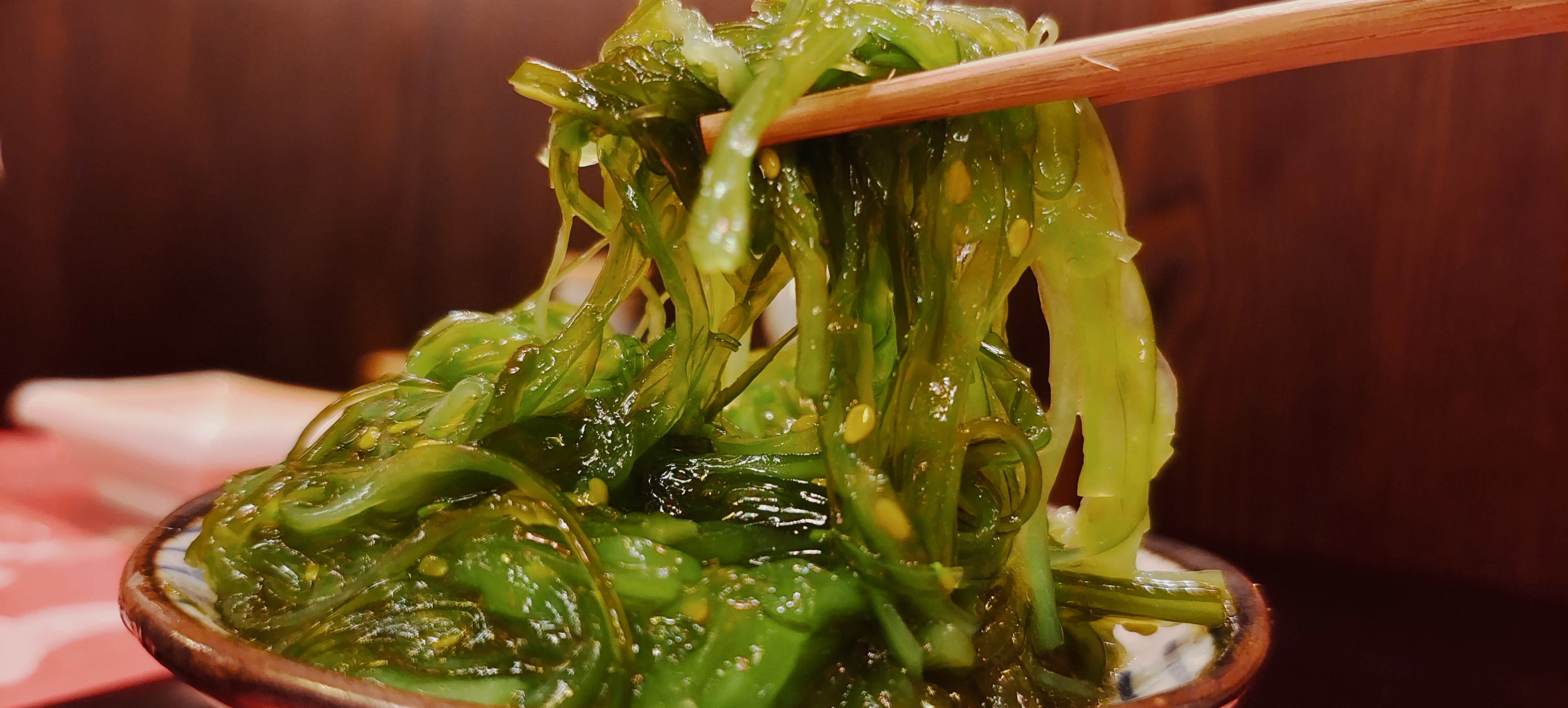 美味海草用筷子夹起，清新自然的美食诱惑