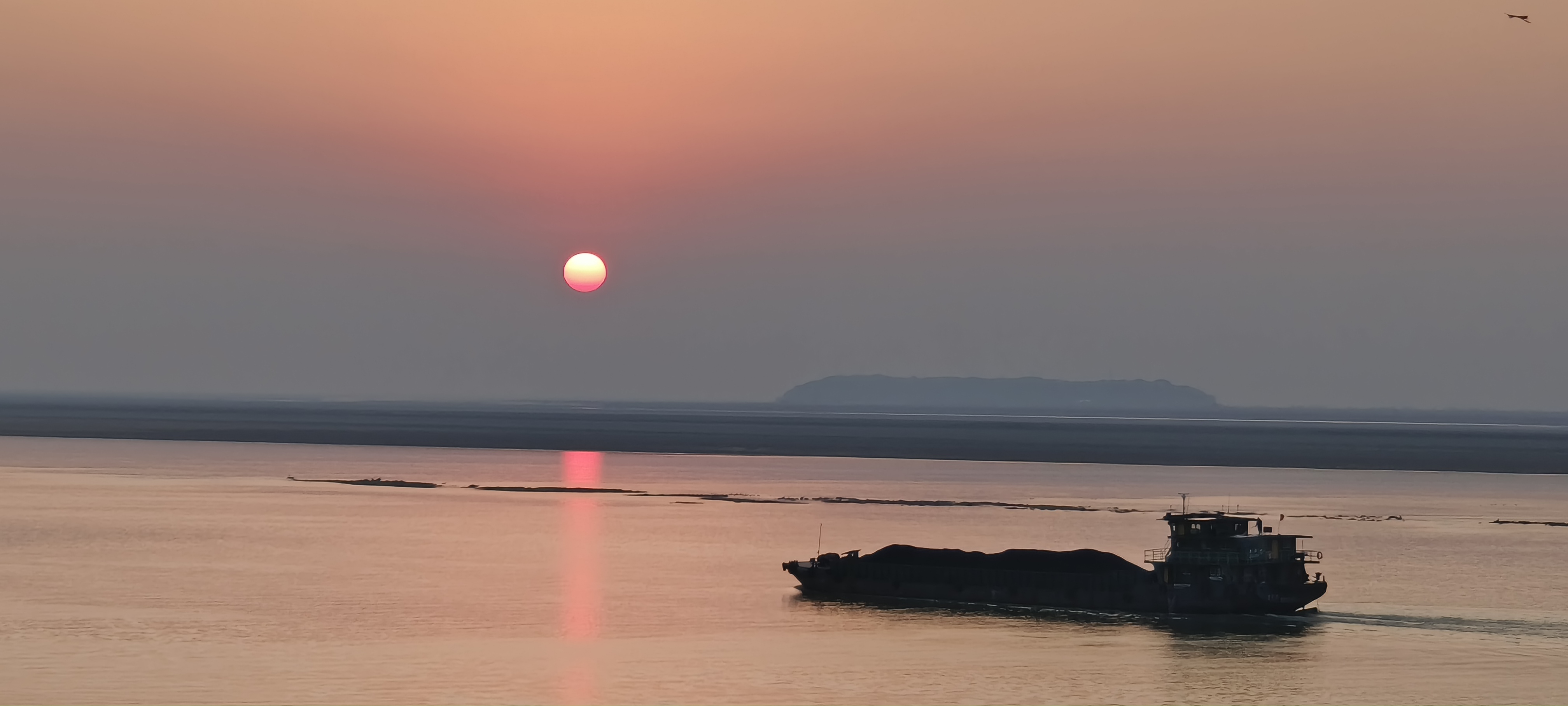 夕阳下的轮船在江面航行的美丽景象