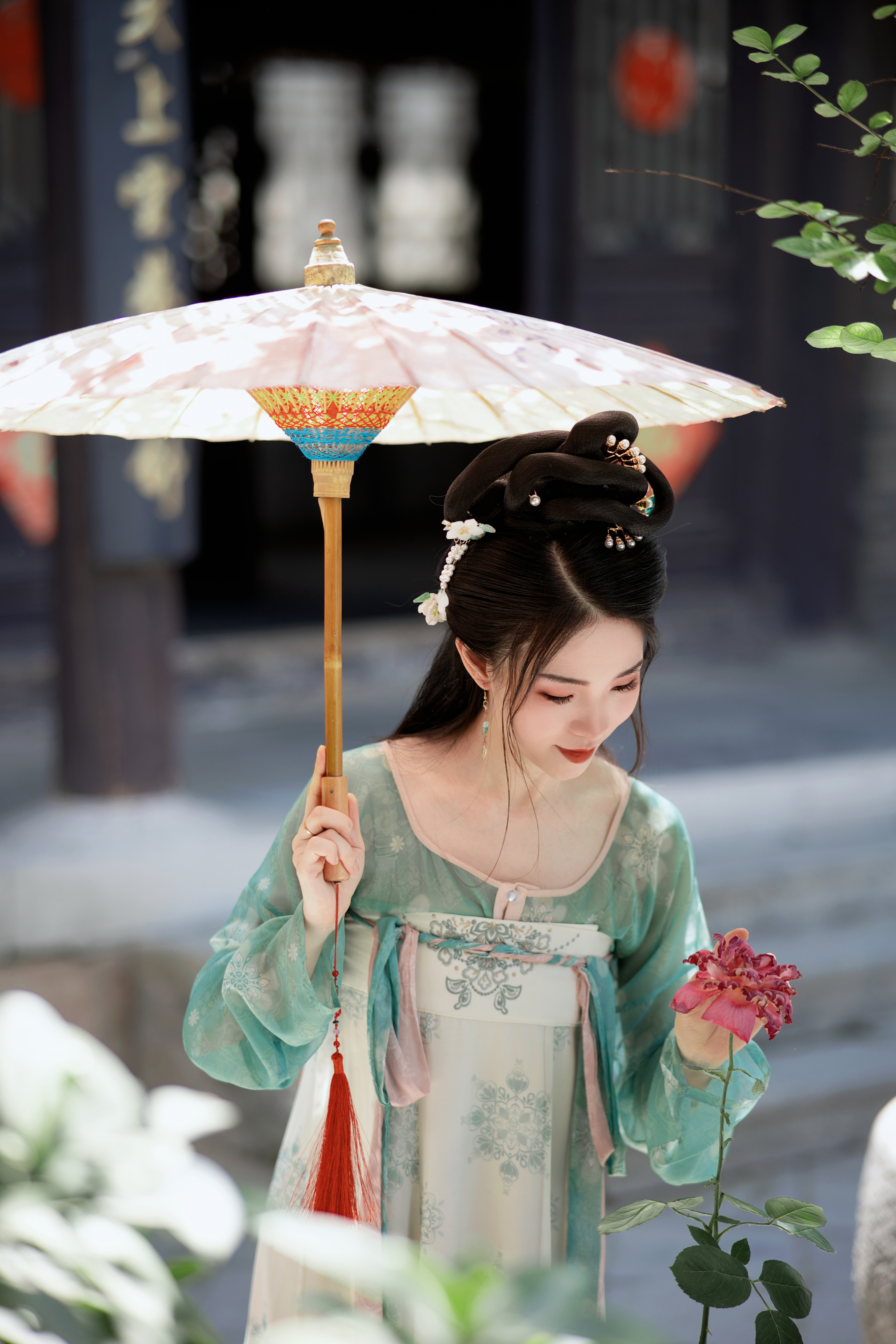 古装女子手持纸伞赏鲜花优雅姿态