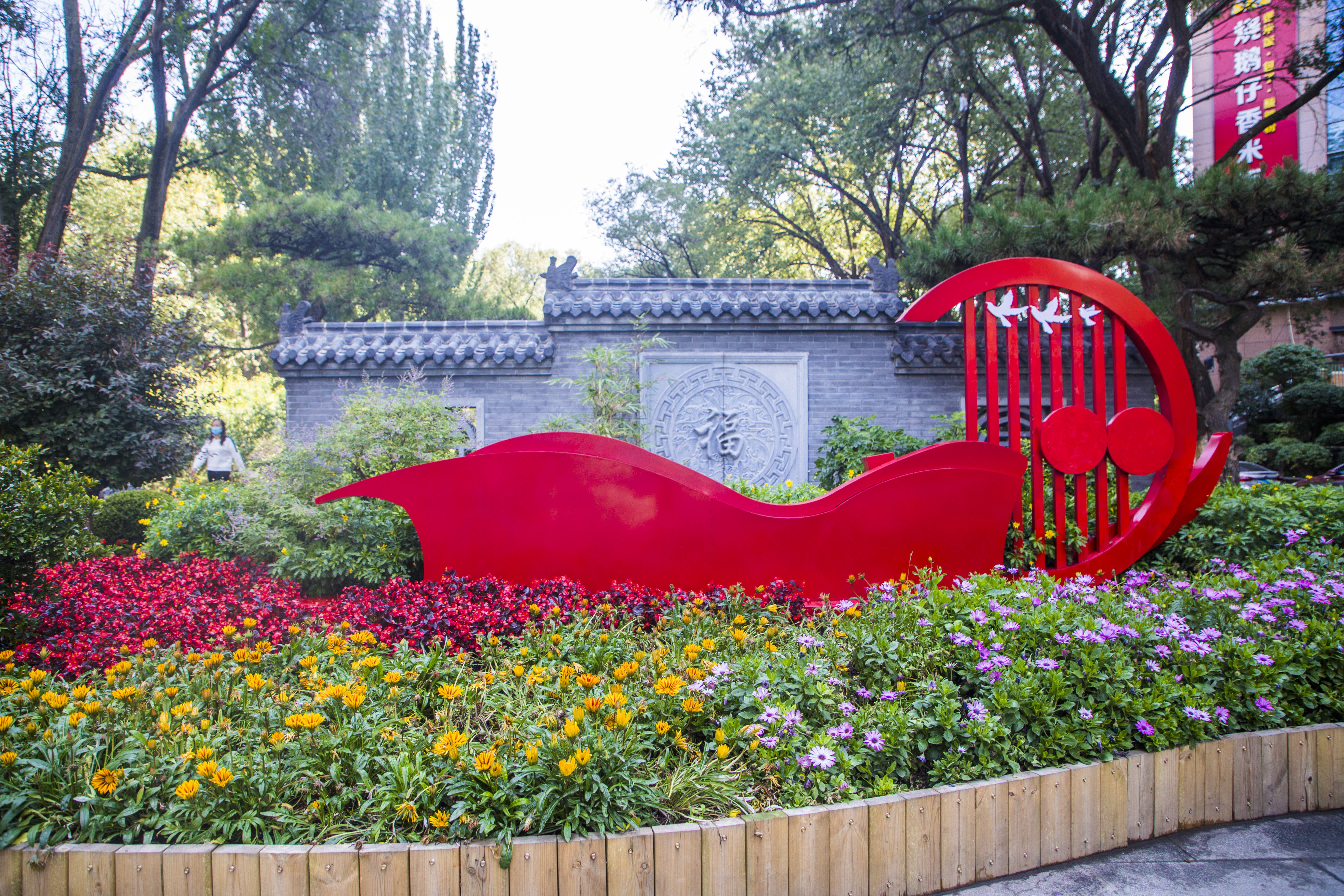 红色雕塑景观扮靓环境 鲜花绿植生机盎然