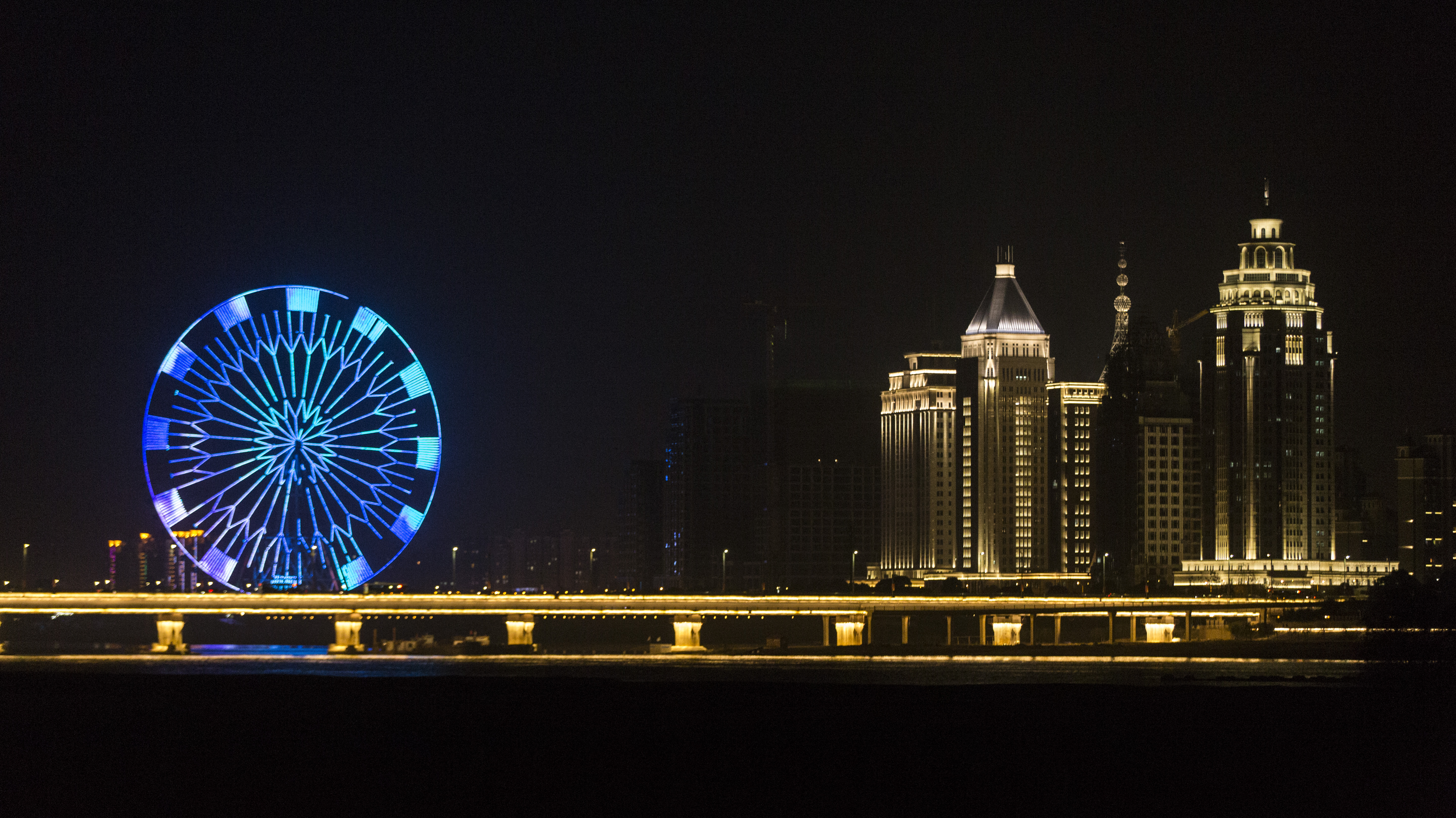 夜幕下的摩天轮与城市建筑灯光璀璨之景
