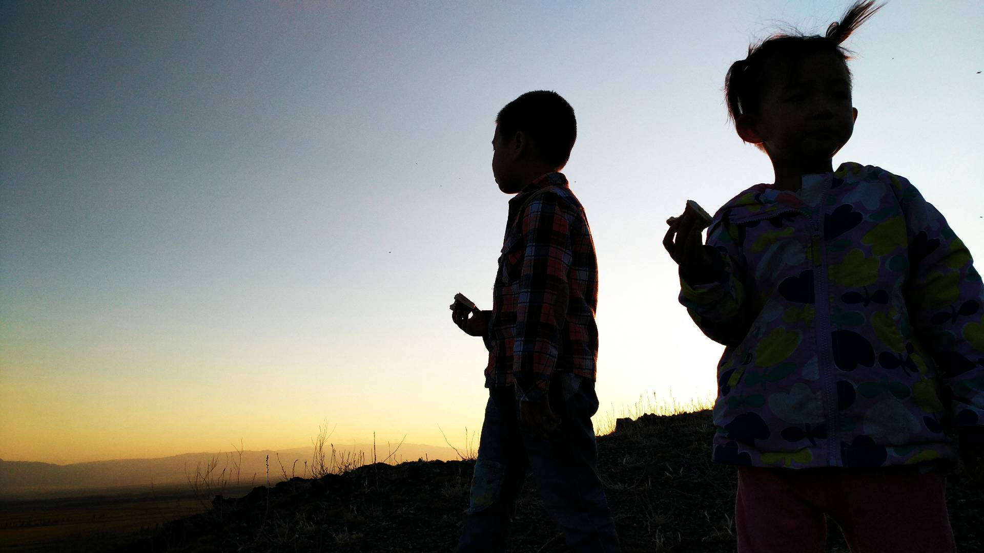 夕阳下孩童剪影，温馨画面尽显童真美好