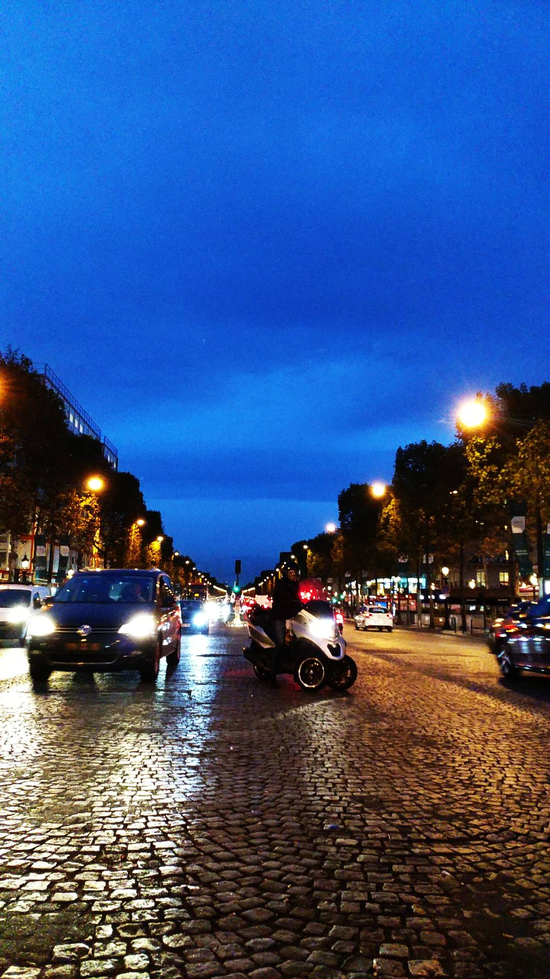 夜幕下的城市街道，摩托车与汽车的光影交织