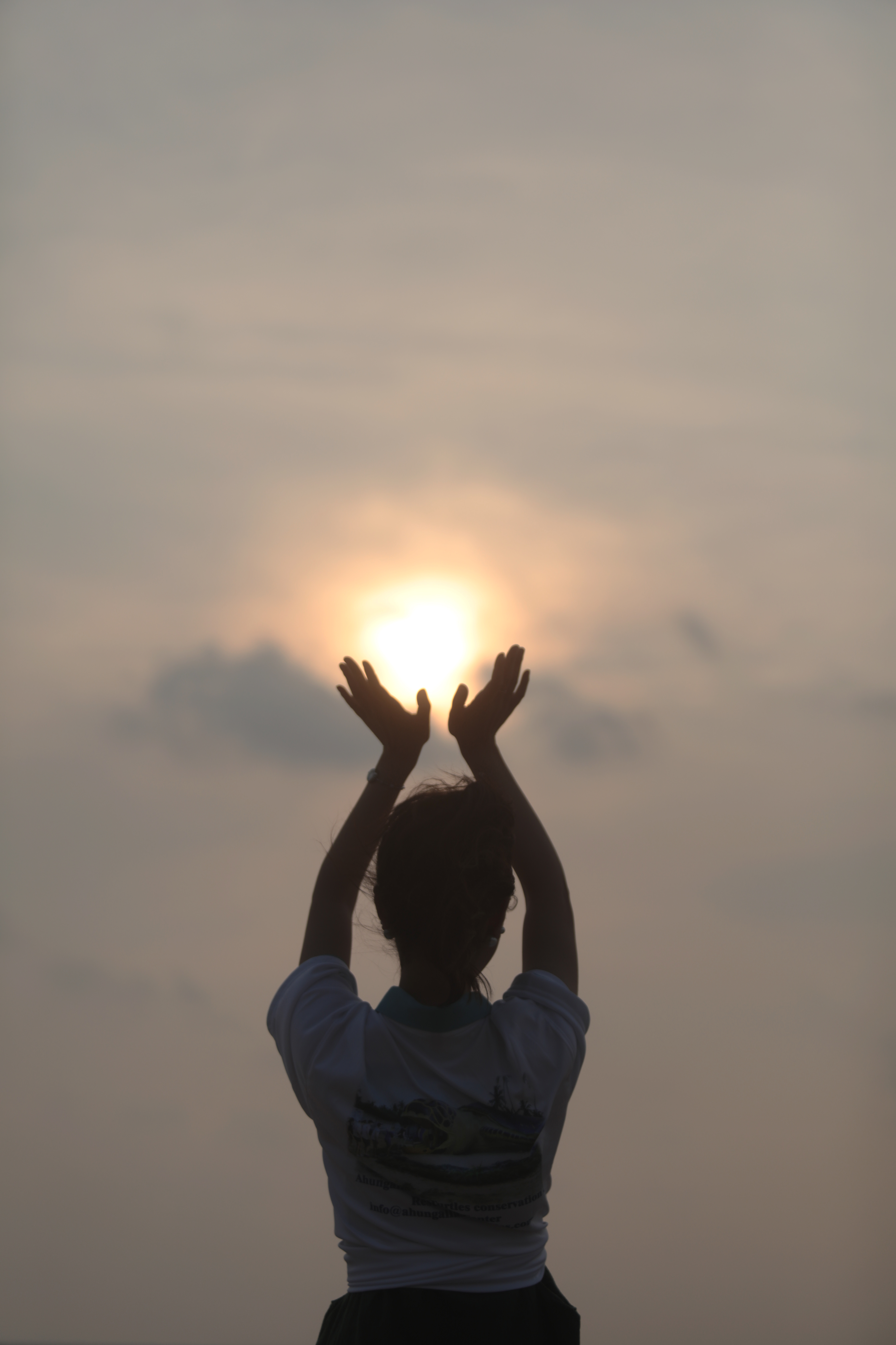 人物双手托举太阳的瑜伽运动剪影图