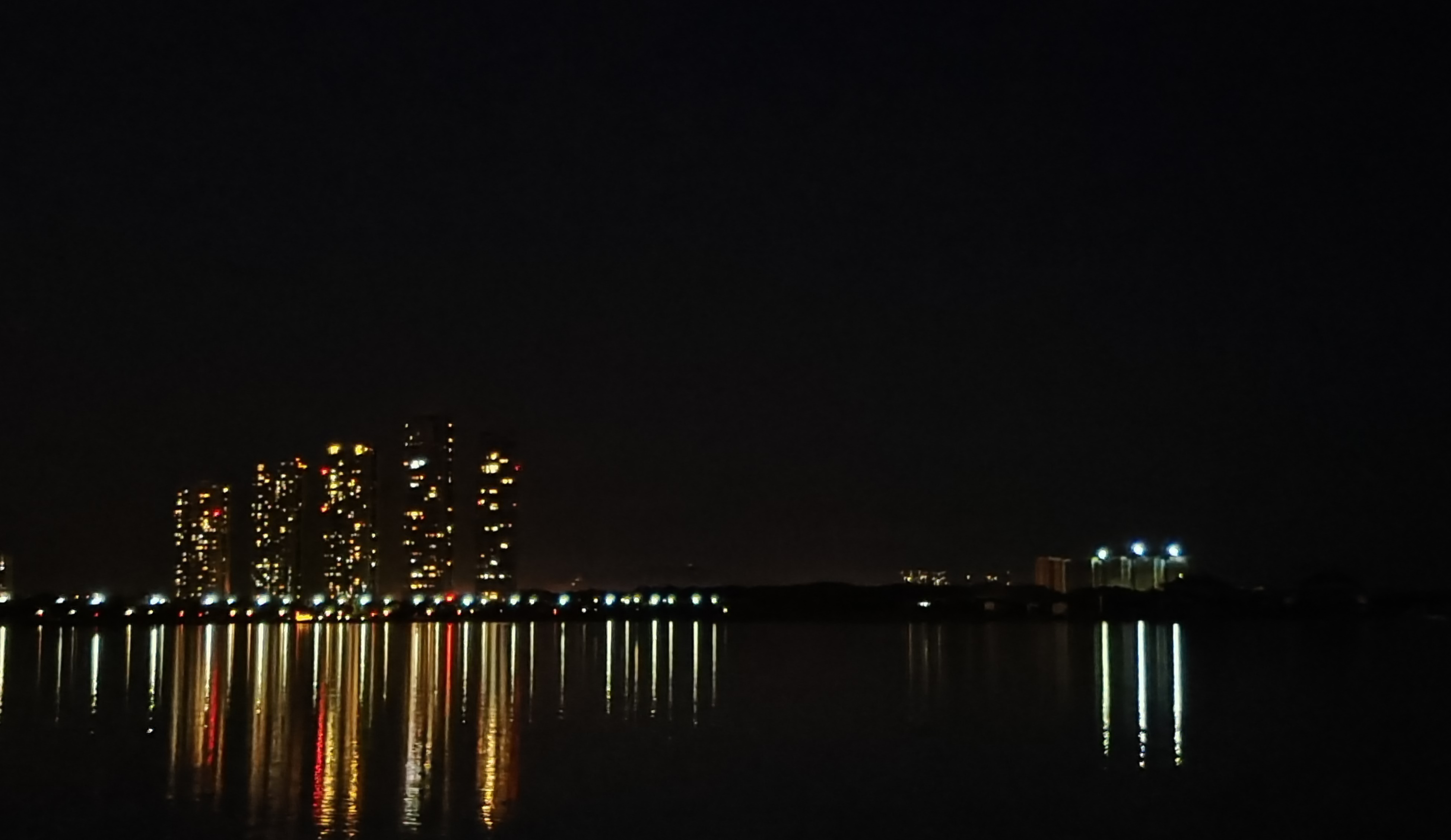 夜色中灯火辉煌的城市倒影在湖泊上的美景